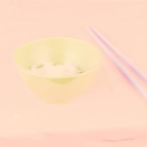 Artificial Paradise by Roy Lee embodies a hazy depiction of a pastel lime green bowl filled with some rice and a pair of chopsticks on a pink surface.