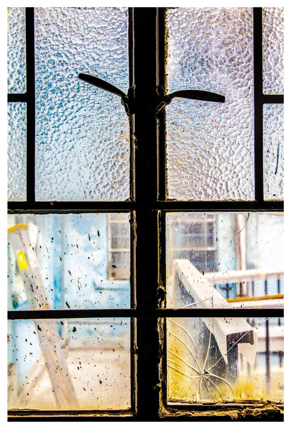 CRACKED WINDOW LOOKING OUT AT CONSTRUCTION FOR REVITALIZATION.